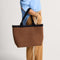 hover | Model holding The Lightweight Zip Tote in ReVelvet Cinnamon.