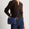 hover | Model wearing The Crossbody Camera Bag in  ReVelvet™ Blue Ink, shown from the front. 