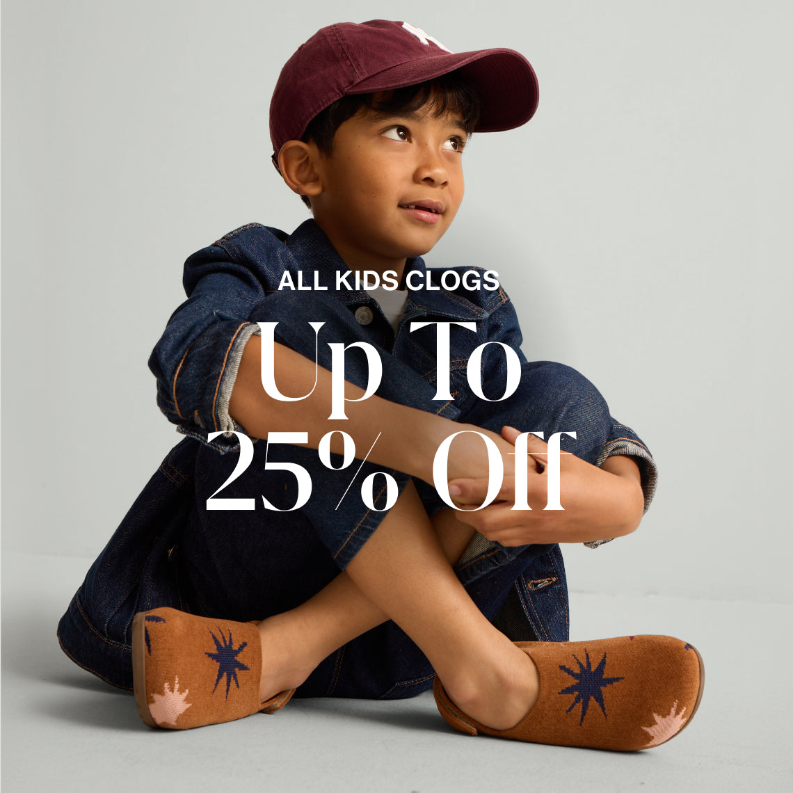 A model wearing The Kids Clog with copy overlay reading ALL KIDS CLOGS | Up To 25% Off