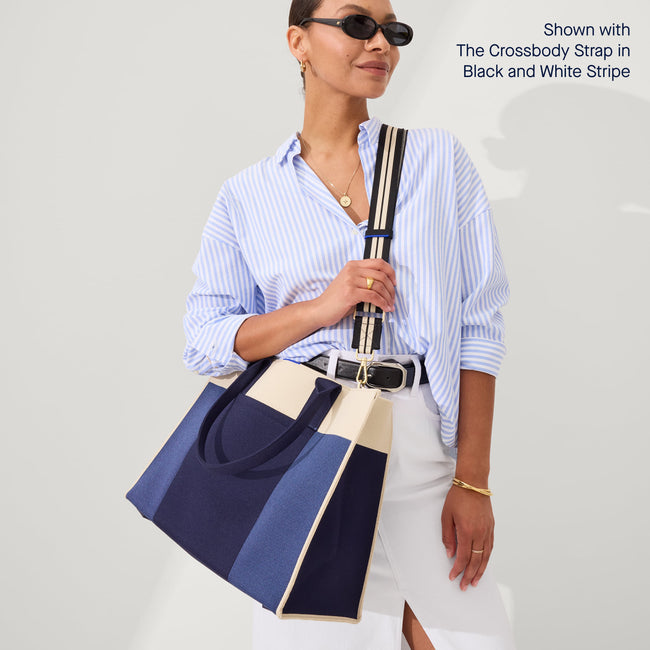 The Classic Tote in Luxe Blue, worn as a crossbody by a model, shown from the front.