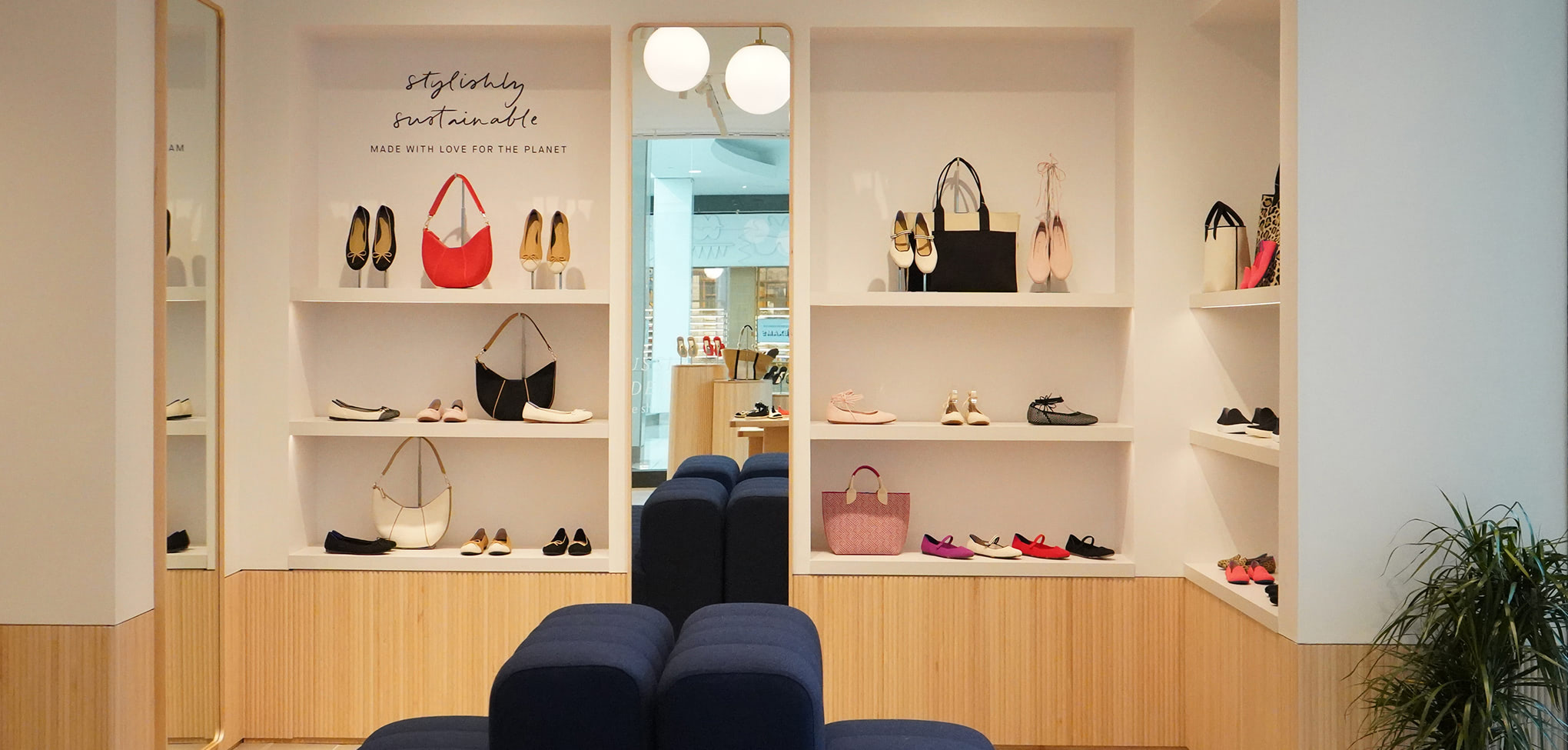 Rothy's display area with various bags and shoes on shelves in a store.