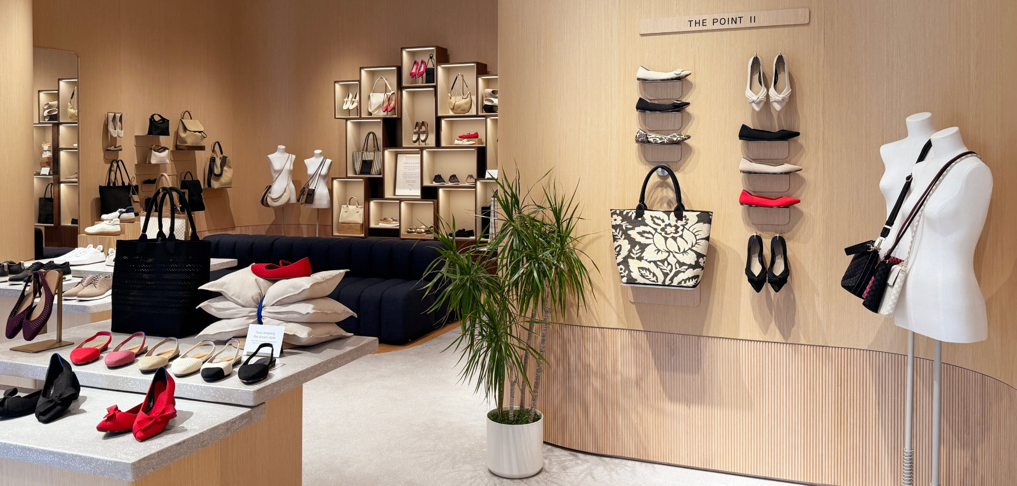 Rothy's store interior with mannequins, shoes, and handbags.