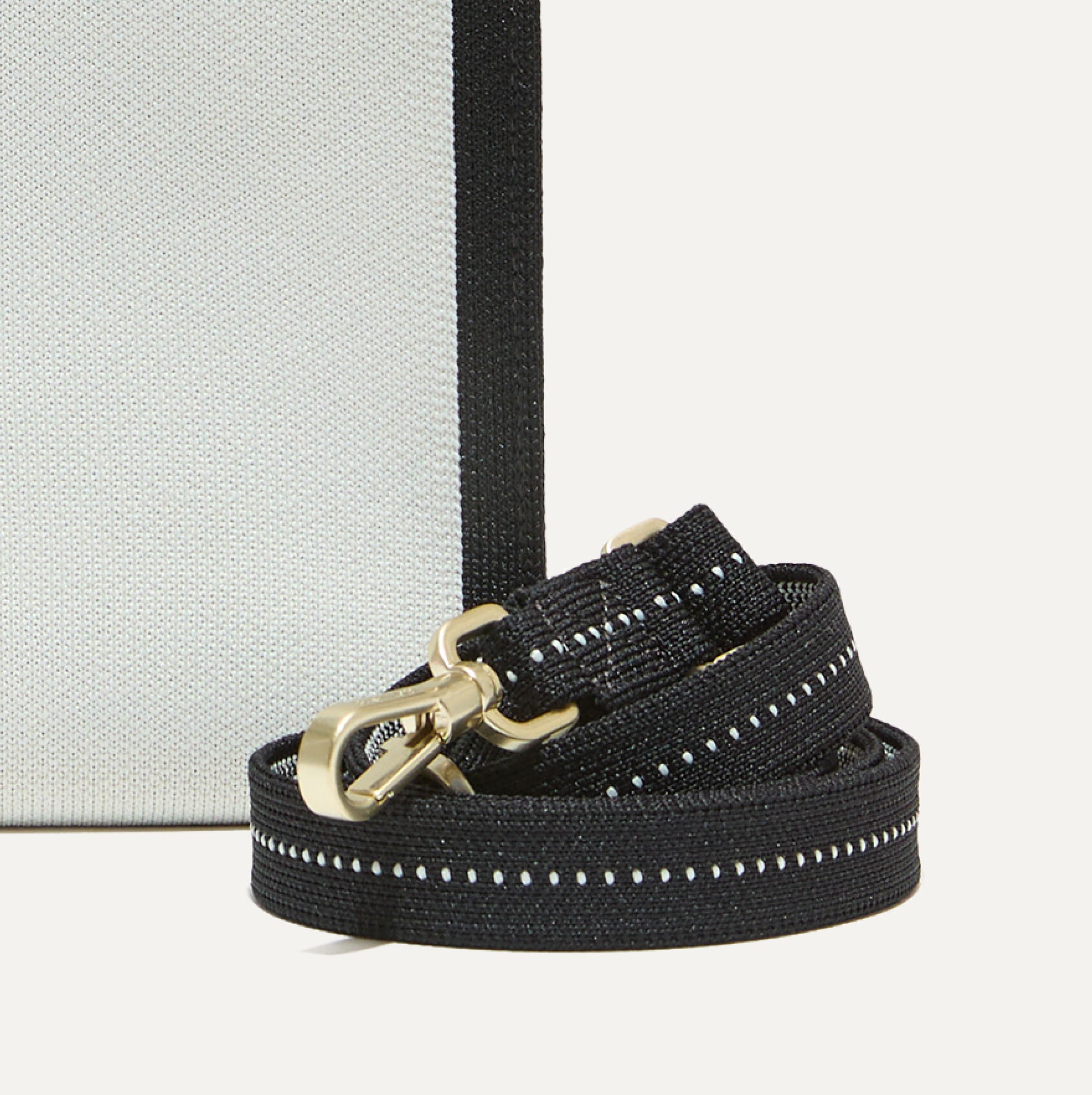 The strap of the Petite Classic Tote shown rolled up.