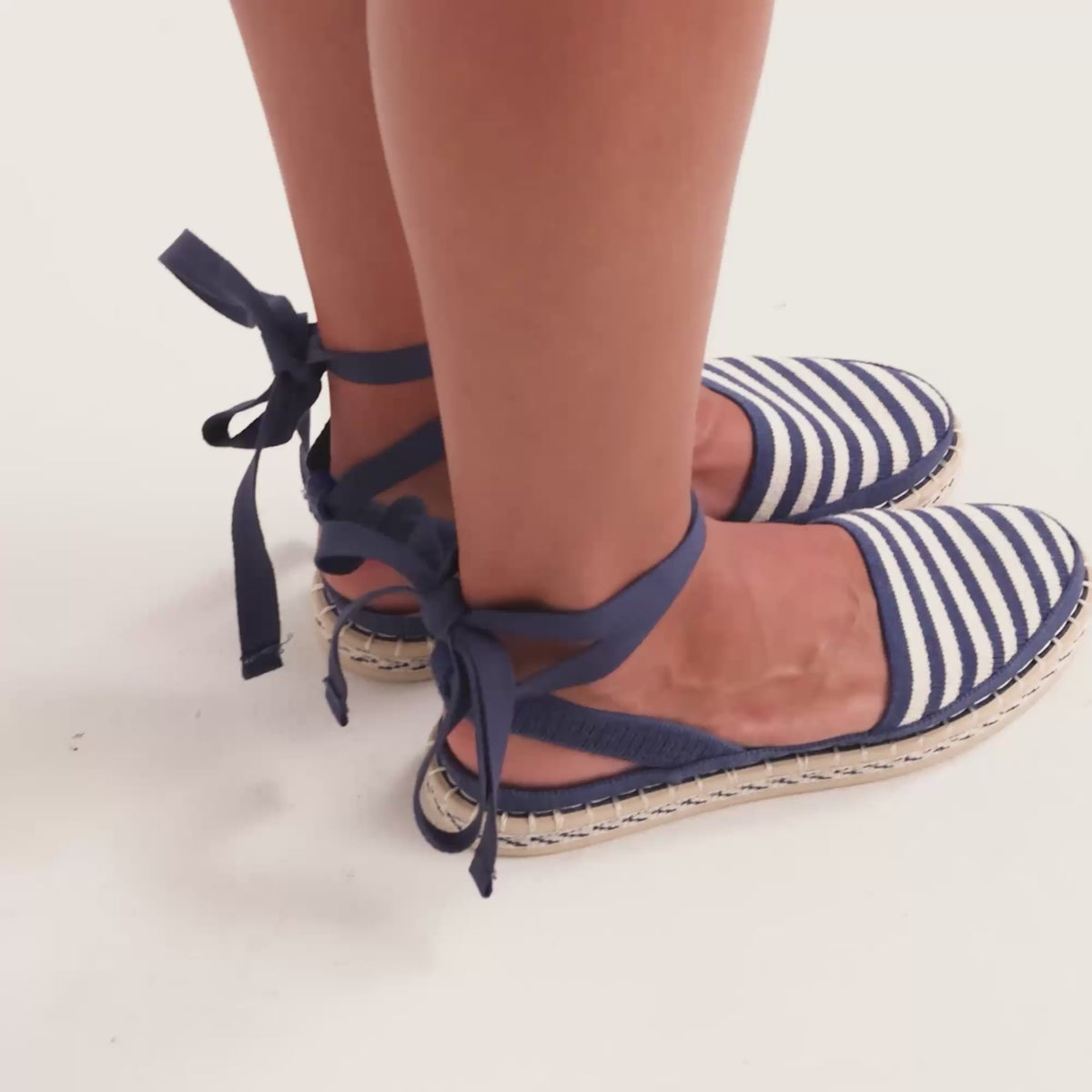 Model walking in The D'Orsay Espadrille in Sailor Stripe while showing different angles of the shoes. 