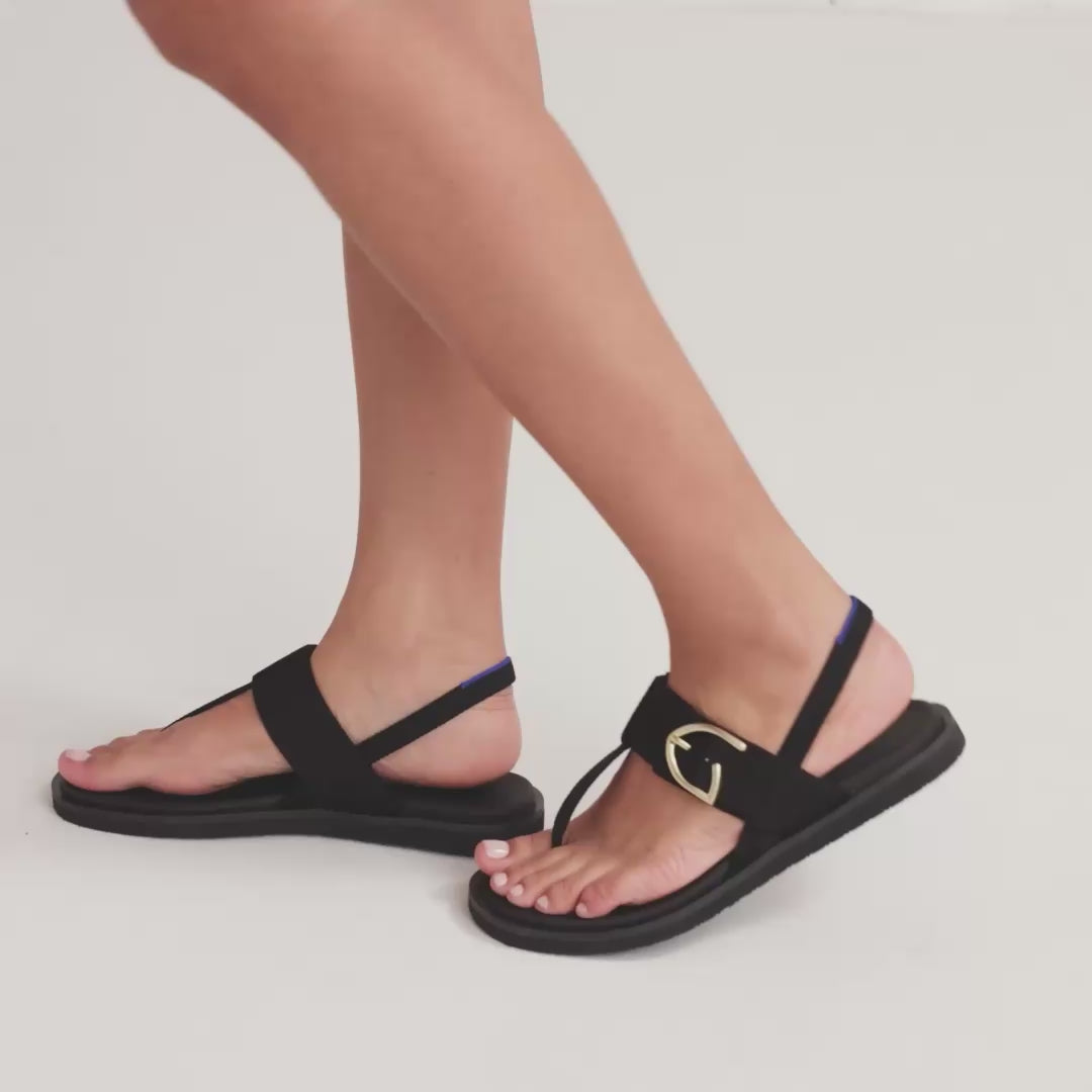 Model walking in The T-Strap Sandal in Black while showing different angles of the shoes. 