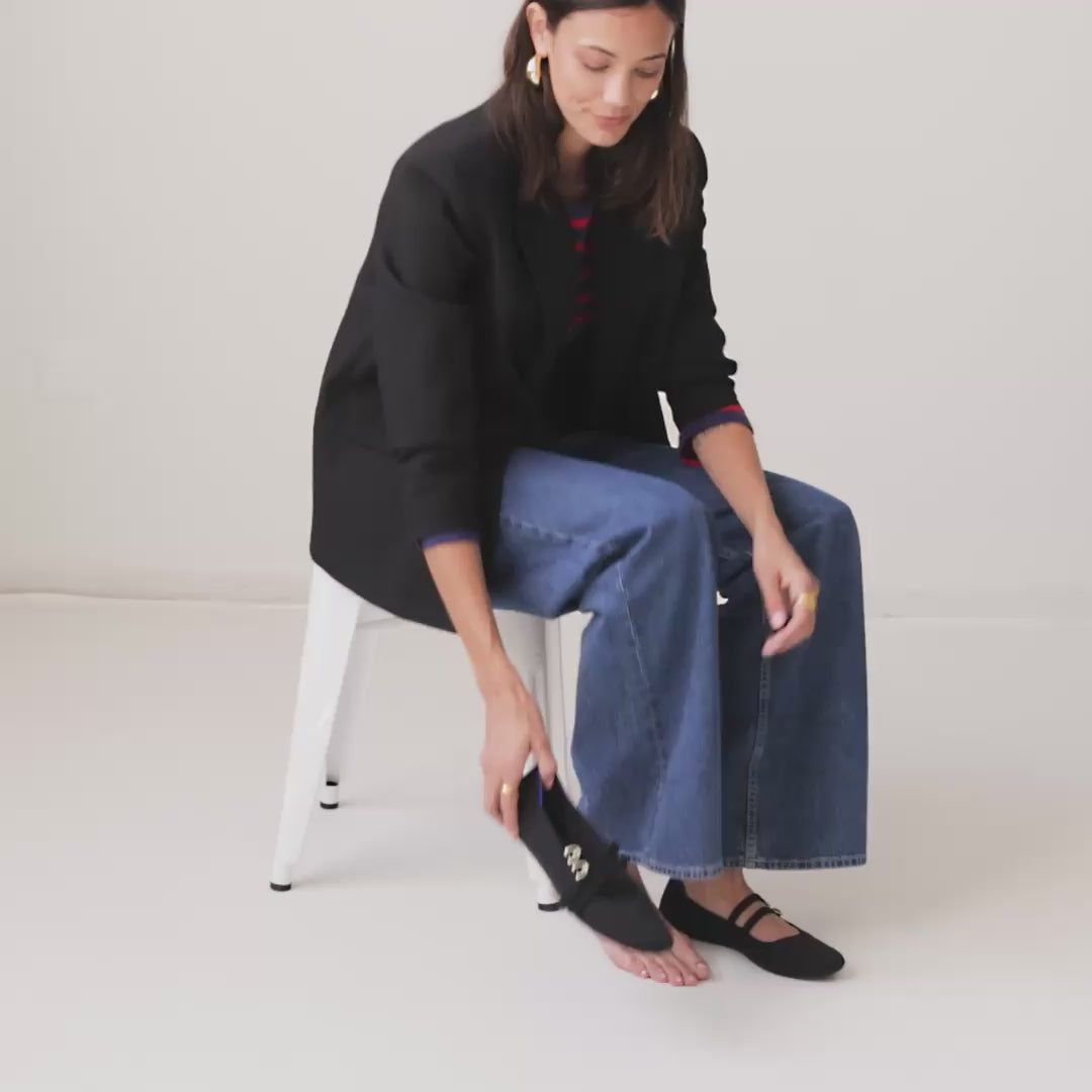 Model walking in The Double Buckle Mary Jane in Black  and showing different angles of the shoes. 