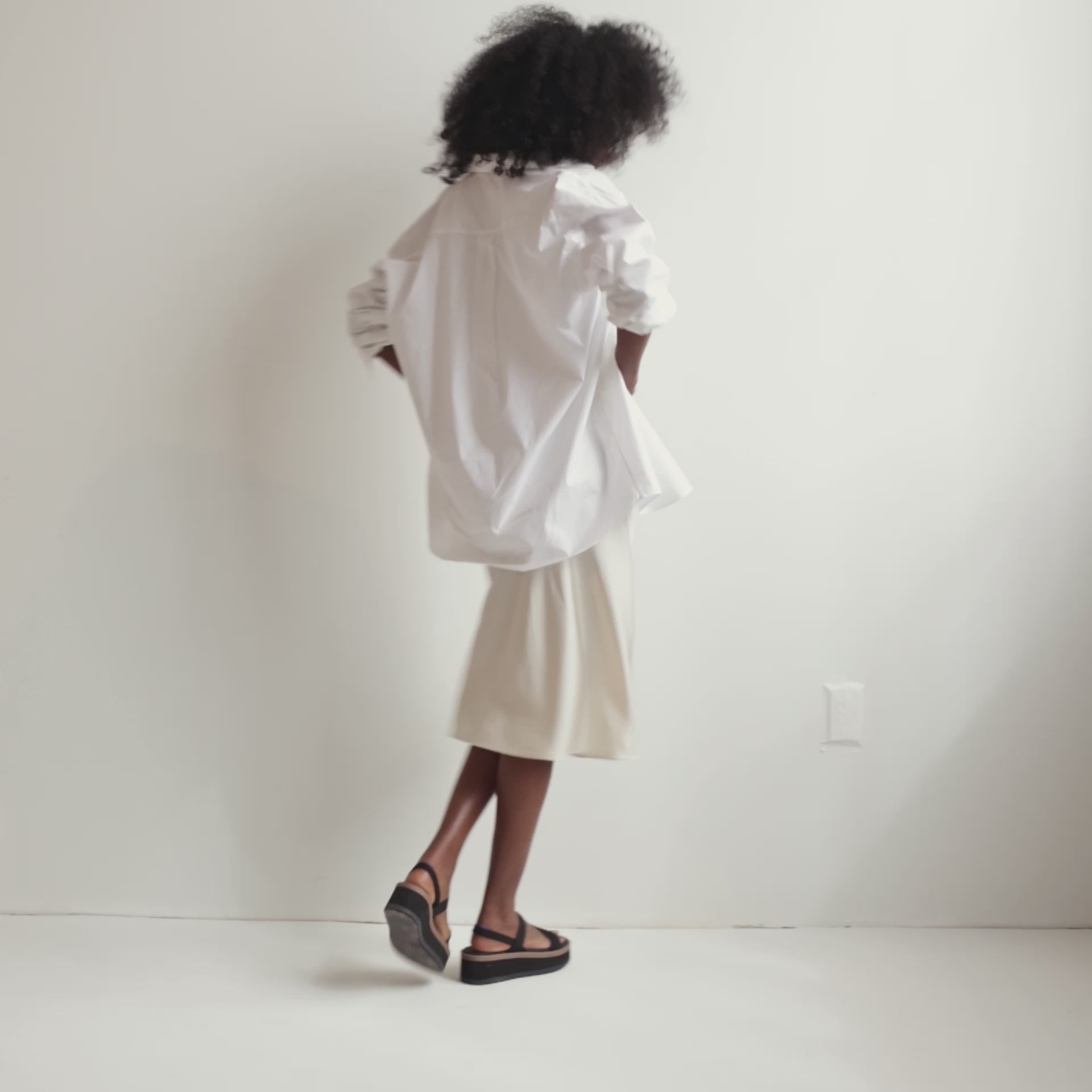 Model walking around in The Lightweight Wedge Sandal in Pepper and showing different angles of the shoe.