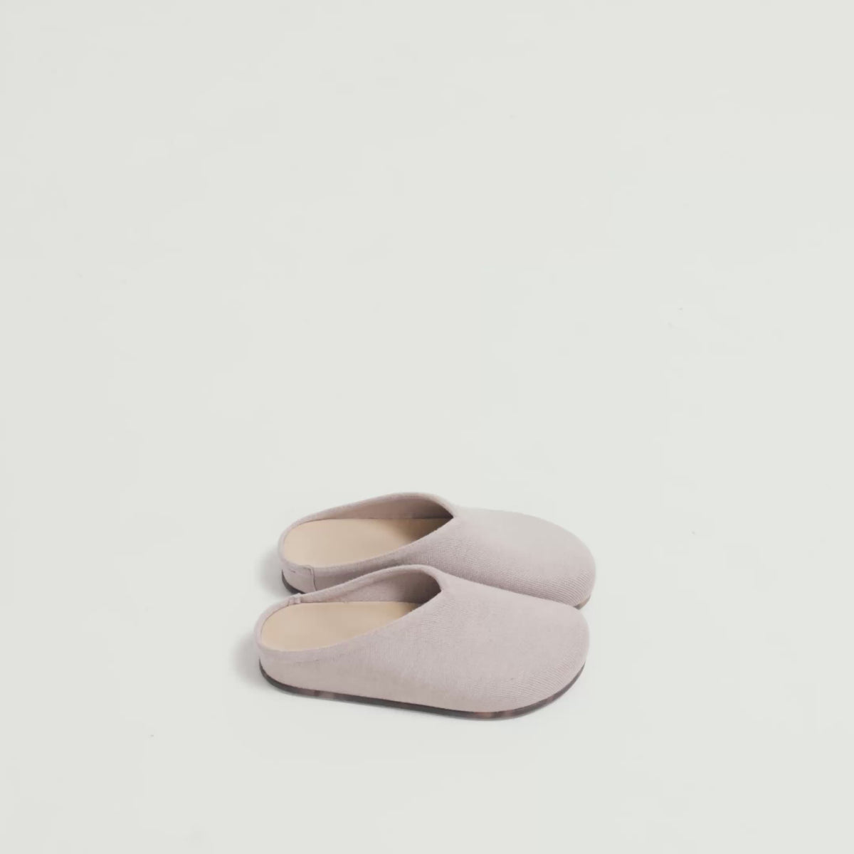 Model walking in The Casual Clog in Dove and showing different angles of the shoes.