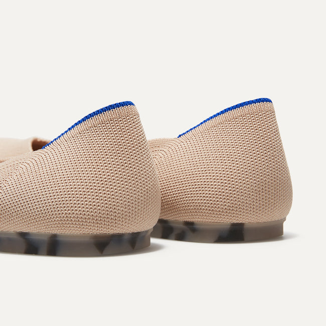 The Flat round toe shoe in Ecru shown from the back view with the heel detail.