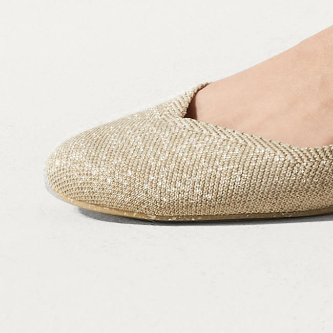 Close up of the rounded toe and v-shaped vamp of The Flat in Light Gold Metallic. 
