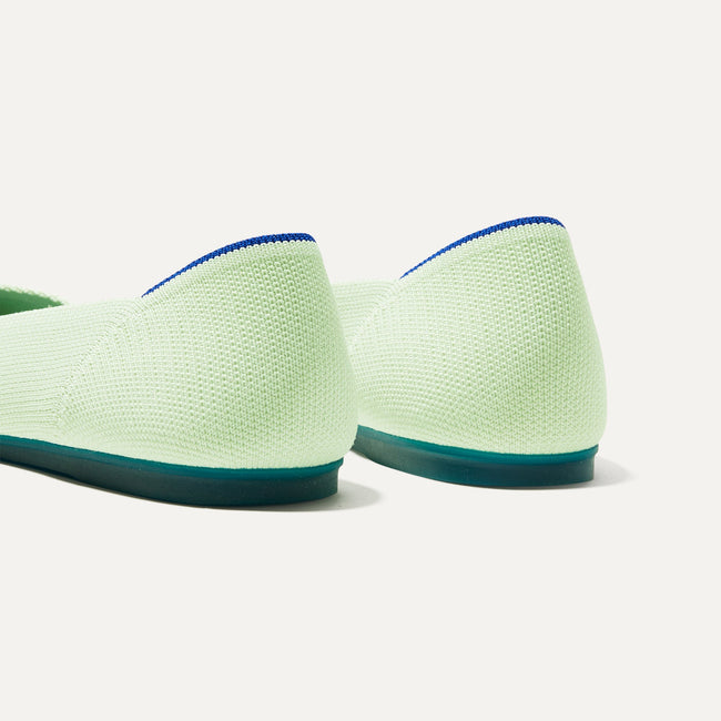 Close up of the heel of The Flat in Sour Apple, with Rothy's signature blue halo. 