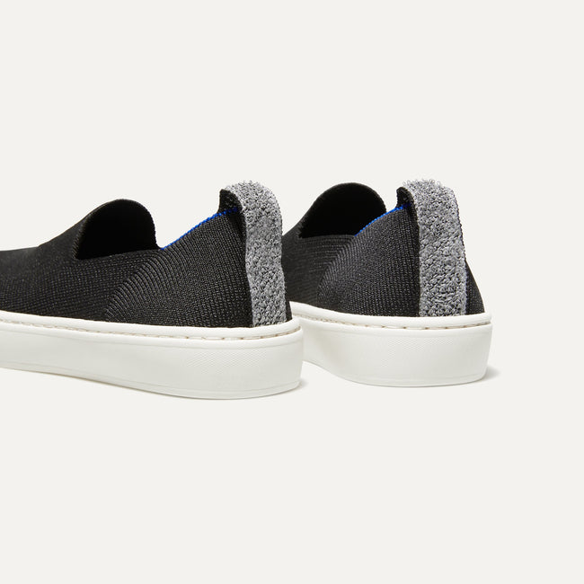 The Kids slip-on Sneaker in Black shown from the back view with the heel detail. 