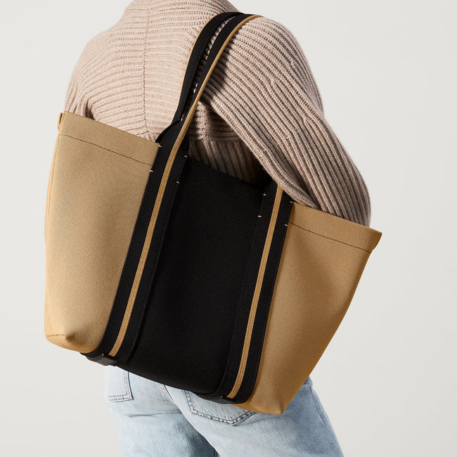 The Essential Tote in Camel and Black worn by a model.
