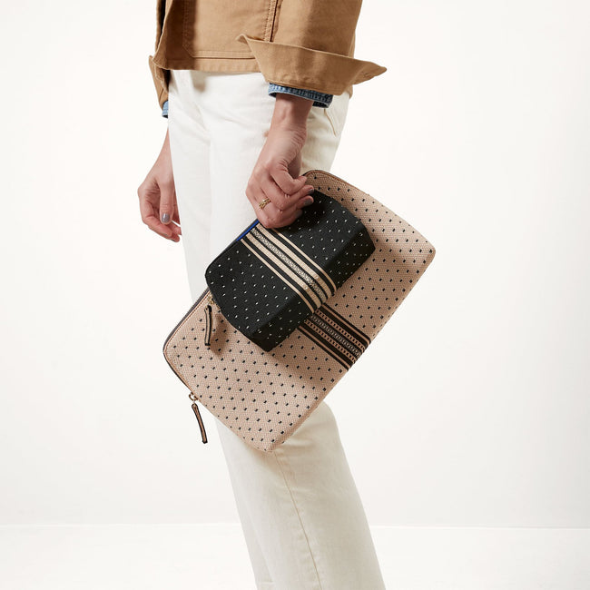 Model shown holding the large and small pouch of The Vanity Set in Tuxedo Stripe.