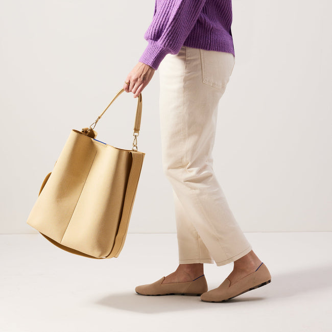 The Bucket Bag in Golden Wheat shown worn differently on model. 