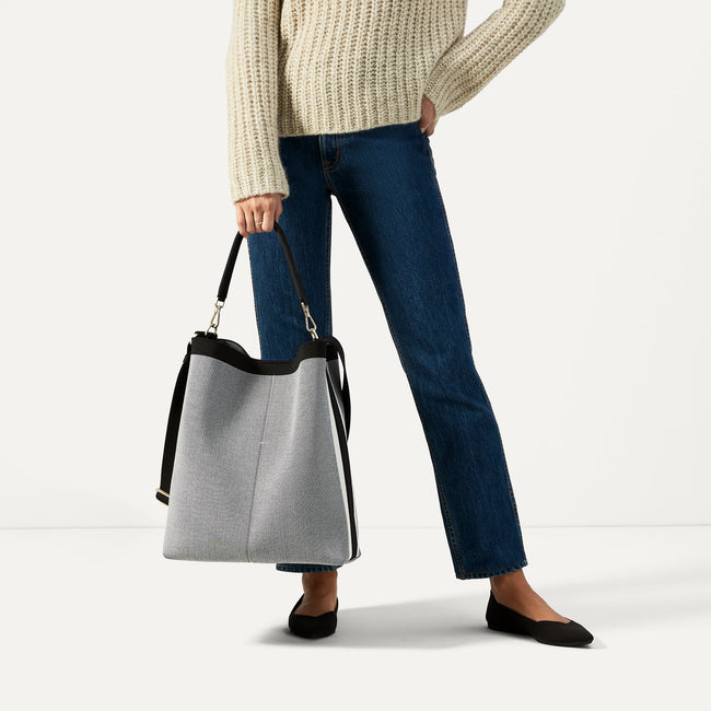 The Bucket Bag in Grey Mist shown worn differently on model.