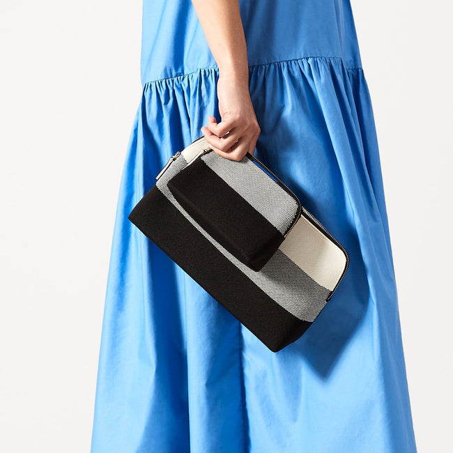 Model shown holding the large and small pouch of The Vanity Set in black mist.