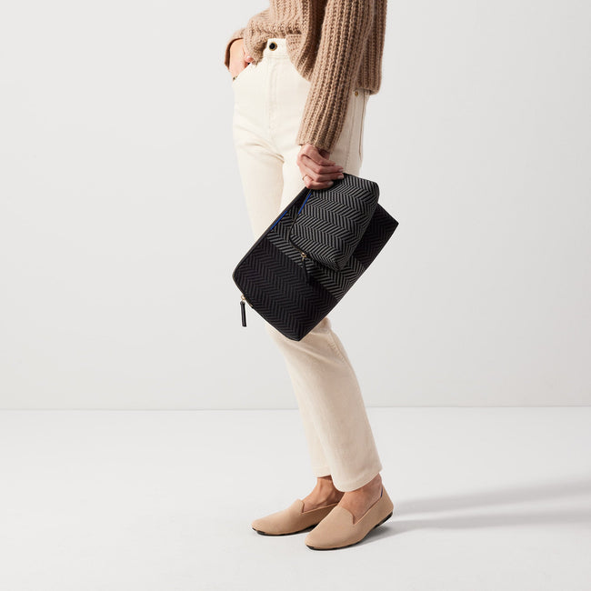 Model shown holding the large and small pouch of The Vanity Set in Shadow Black.