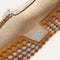 Close up of the outsoles of The Driving Loafer in Sand Trap, with raised nub details and the Rothy's signet on the base of the shoe. 