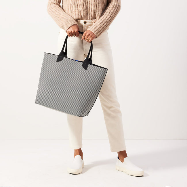 hover | Model holding The Lightweight Tote in Black & White Stripe.