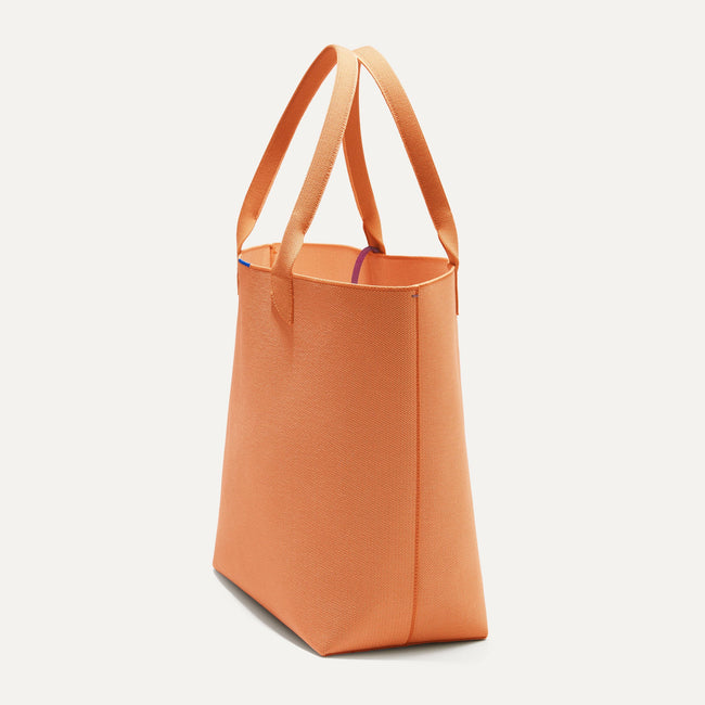 The Lightweight Tote in Clementine shown in diagonal view. 