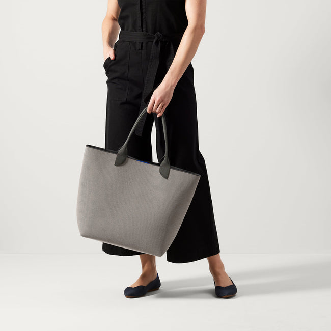 An alternate view of model holding The Lightweight Tote in Iron Grey.