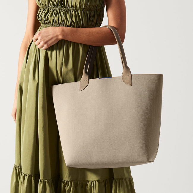 Model holding The Lightweight Tote in Soft Sesame.