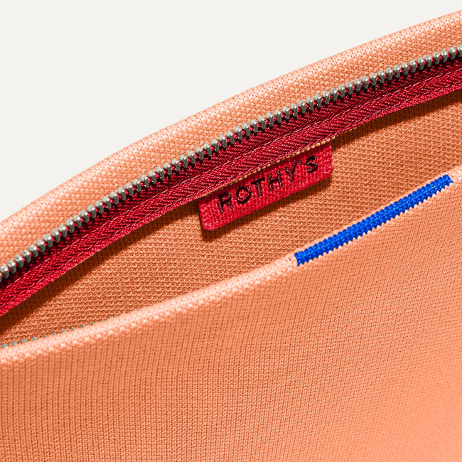 The Wristlet in Clementine interior view with Rothy's halo detail.