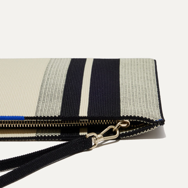 Close up of the zipper closure and wrist strap of The Wristlet in ivory Rugby Stripe.