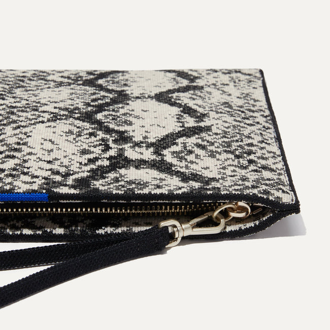 Close up of the zipper closure and wrist strap of The Wristlet in Python.