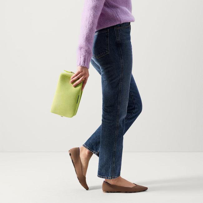 The Universal Pouch in Lemon Lime held by model in a different view.