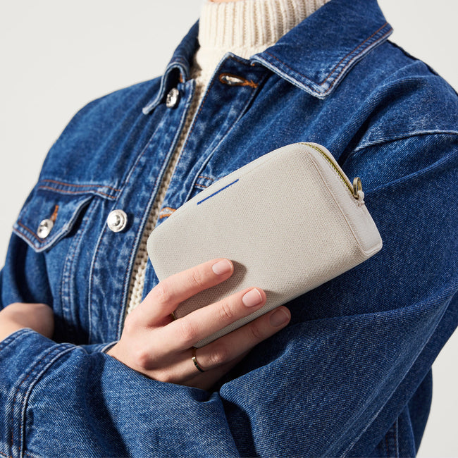 hover | The Mini Universal Pouch in Alabaster held by model.