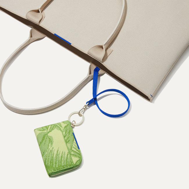 The Wallet Keychain in Palm Leaf shown attached to keyleash of The Lightweight Tote.