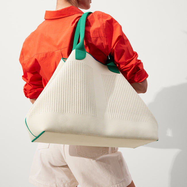 hover | The Lightweight Mega Tote in Courtside White, worn over the shoulder by a model, shown from the side. 