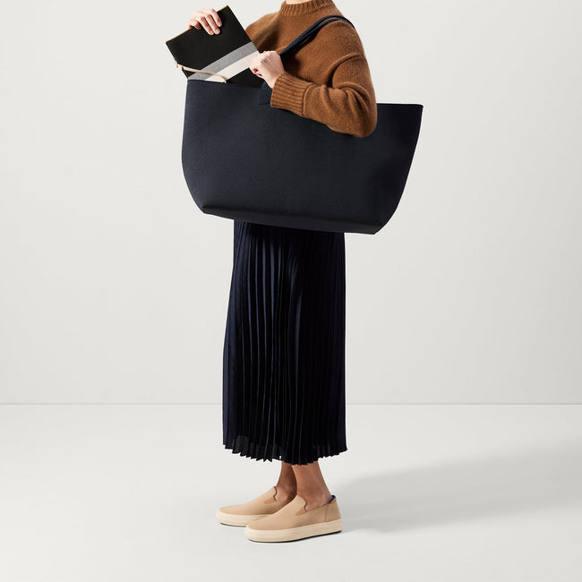 The Lightweight Mega Tote in Navy Twill, worn over the shoulder by a model, shown from the side. 