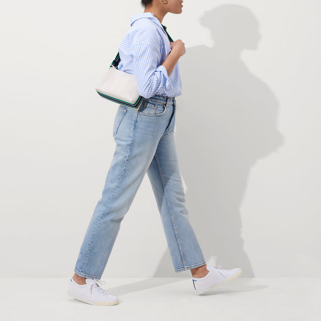 The Casual Crossbody in Courtside White, worn as a crossbody by a model, shown from the side.