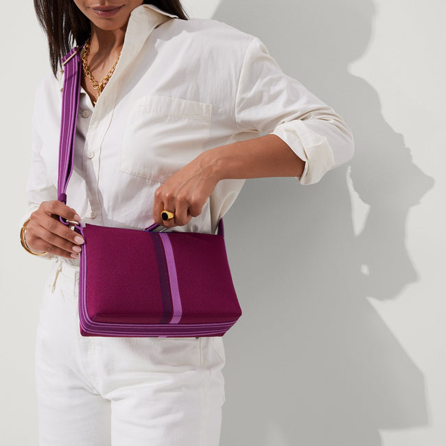 hover | The Casual Crossbody in Plum Stripe, worn as a crossbody by a model, shown from the front. 